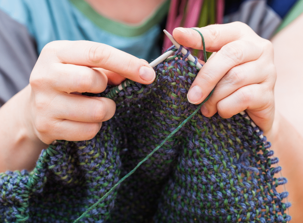 a pair of pale knitting hands