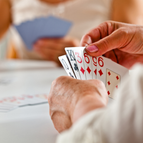 pale set of hands holding playing cards