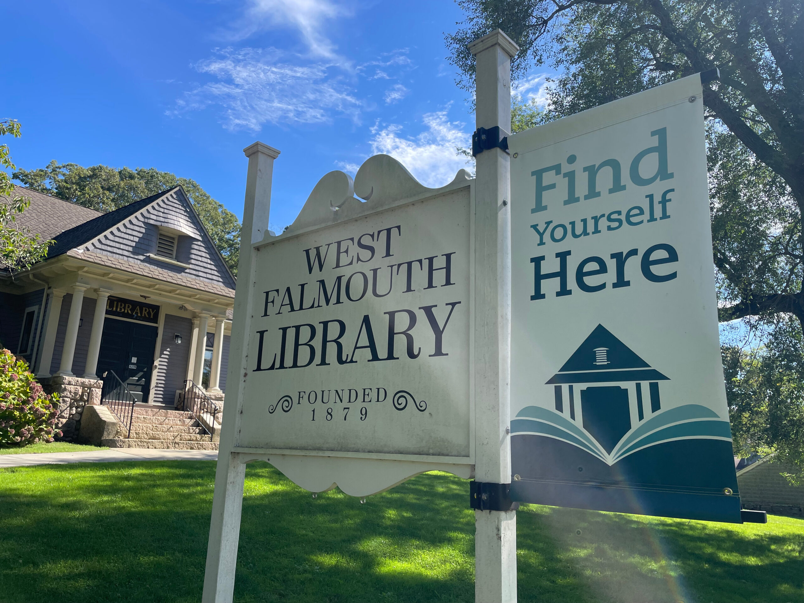 exterior daytime shot of West Falmouth Library with sign in the forefront