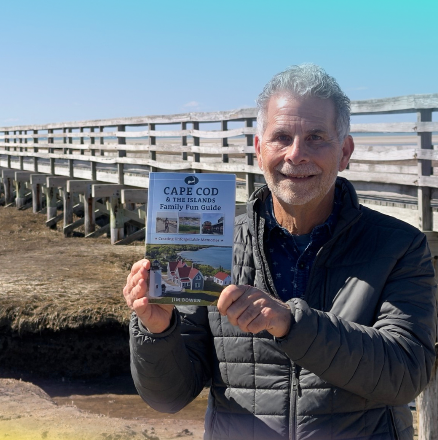 Cape Cod author jim bowen posing at Sandwich Boardwalk with his book Cape Cod and the Islands Family Fun Guide