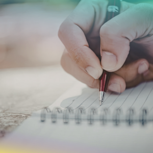 stock photo of pale hand writing in a notebook