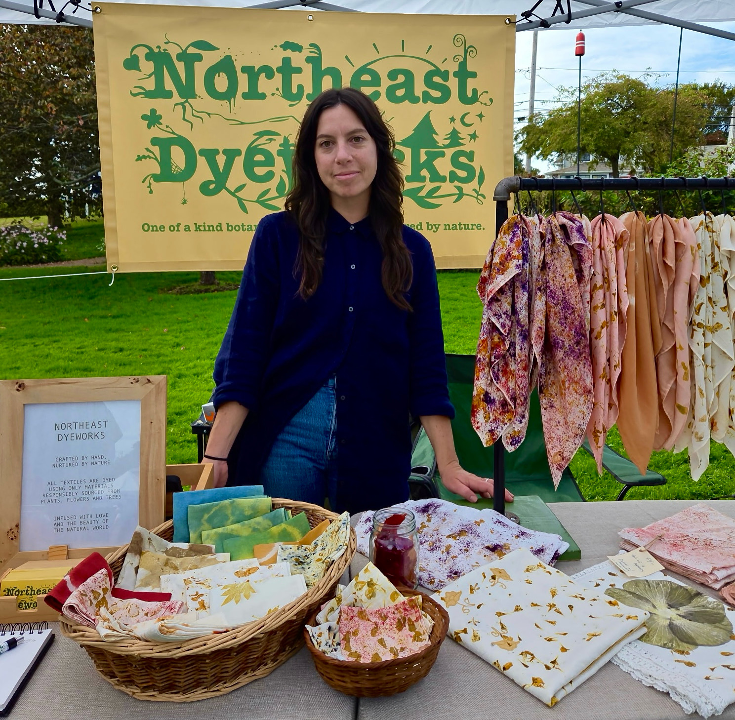 Rebecca Zaremba of Northeast Dyeworks standing at a vendor table of her wares