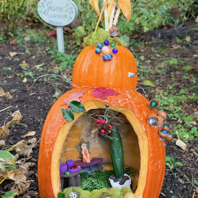 A whimsically carved pumpkin featured in the Harvest Fairy installation at the gardens of West Falmouth Library October 2026